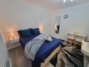 a bedroom with a bed with a teddy bear on it at Relaxed Double bed with private bathroom, parking, WiFi and garden. in Leeds