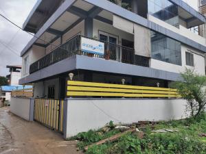 un bâtiment avec un banc jaune sur son côté dans l'établissement Hotel SRI KPN , Austinabad, à Austinābād