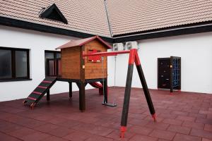 uma pequena casa de jogos de madeira com uma escada em Hotel Vír em Vír