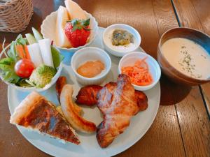 einen Teller mit Lebensmitteln mit Fleisch, Gemüse und Dips in der Unterkunft Family Hotel Matsumoto Satoyama Doors in Matsumoto