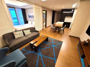 W Residence Hotel في بوسان: غرفة معيشة مع أريكة وغرفة نوم