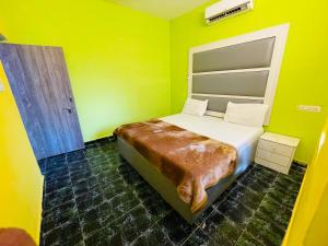 ein Schlafzimmer mit einem Bett in einem gelben Zimmer in der Unterkunft Js Private villa with pool in Calangute