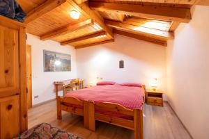 a bedroom with a bed in a room with wooden ceilings at Agritur B&B Iellici in Castello di Fiemme