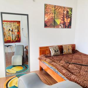 1 dormitorio con cama, espejo y silla en Nhà nghỉ Bảo Trâm, en Chau Doc