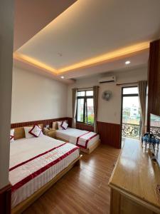 a hotel room with two beds and a balcony at Hotel Như ý Biên Hòa in Bien Hoa