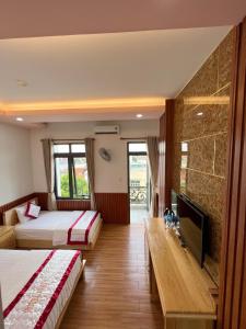 um quarto de hotel com duas camas e uma televisão de ecrã plano em Hotel Như ý Biên Hòa em Bien Hoa