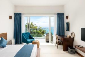 a hotel room with a bed and a desk and a window at Vis Ta Vie -Thema Collection in Mirissa