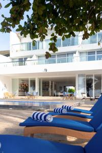 a row of blue lounge chairs in front of a building at Vis Ta Vie -Thema Collection in Mirissa