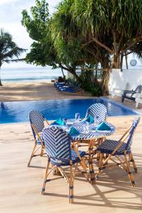 a table and chairs next to a swimming pool at Vis Ta Vie -Thema Collection in Mirissa