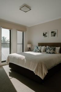 a bedroom with a large bed and a large window at Yarrawonga Waterfront Apartments in Mulwala