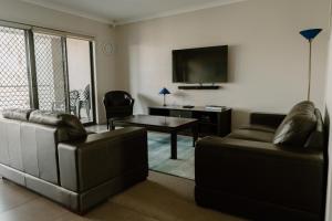 een woonkamer met 2 banken en een tv bij Yarrawonga Waterfront Apartments in Mulwala