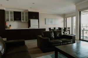 a living room with a couch and a kitchen at Yarrawonga Waterfront Apartments in Mulwala