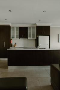 een keuken met zwarte kasten en een witte koelkast bij Yarrawonga Waterfront Apartments in Mulwala