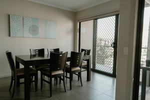 a dining room with a black table and chairs at Yarrawonga Waterfront Apartments in Mulwala