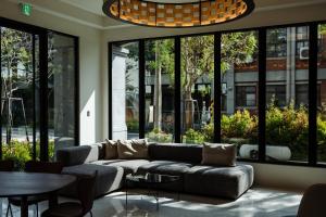 a living room with a couch and a table and windows at 綉溪安平 in Anping