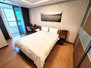 um quarto de hotel com uma cama e uma secretária em W Residence Hotel em Busan
