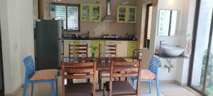 a kitchen with a table and chairs and a refrigerator at Ram@nasik in Nashik
