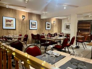 a dining room with tables and red chairs at Hotel Restaurant Le Clos in Besse-et-Saint-Anastaise