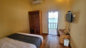a bedroom with a bed and a television and a window at Kelong Pancing Madu Tiga in Tanjung Pinang 