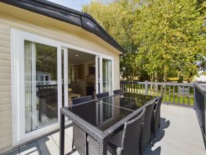 a screened porch with a table and chairs on a deck at Tattershall Lakes Mini Breaks - The Avenue in Lincoln