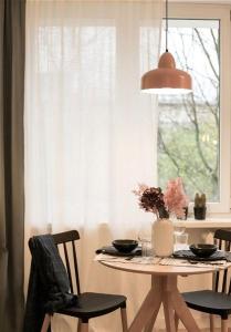 a dining room table with chairs and a window at ECRU Designer Studio with Bedroom near Old Town WWA56 in Warsaw