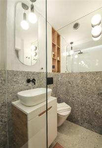 a bathroom with a sink and a toilet and a mirror at ECRU Designer Studio with Bedroom near Old Town WWA56 in Warsaw