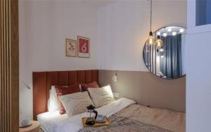 a bedroom with a bed with a mirror on the wall at ECRU Designer Studio with Bedroom near Old Town WWA56 in Warsaw