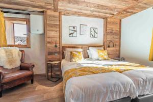 Un dormitorio con una cama grande y una silla en CHALET CHARMING BED and BREAKFAST, en Les Gets