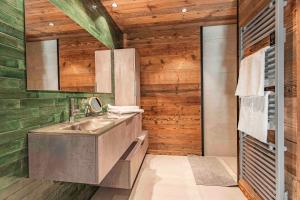 uma casa de banho com um lavatório e uma parede de madeira em Chalet CHARMING B AND B em Les Gets