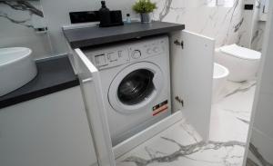 uma lavandaria com uma máquina de lavar e secar roupa na casa de banho em AG apartment em Cormano