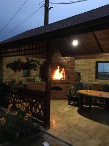 a fireplace in a brick building with a table and a fire at MYONNA Style Slobozia 