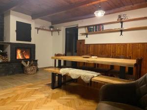 a living room with a table and a fireplace at Je-sen, ubytování na horách s bazénem a infrasaunou in Jeseník