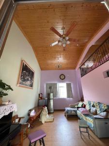 uma sala de estar com uma ventoinha de tecto e um sofá em GO Bill B&B em Xinyi