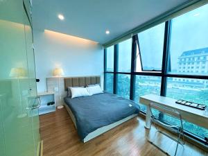 - une chambre avec un lit, un bureau et des fenêtres dans l'établissement May Apartment My Dinh Hanoi, à Hanoï