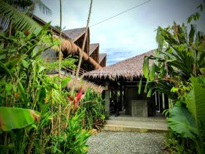 un edificio resort con techo de paja en The Ohm Siargao Resort, en General Luna