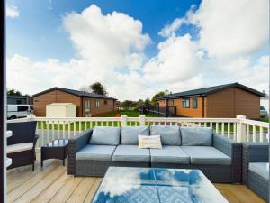 a living room with a couch on a deck at Tattershall Lakes Mini Breaks - Osprey Rise in Tattershall
