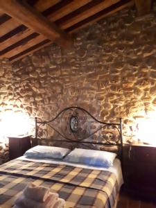 a bedroom with a bed in a stone wall at Agriturismo Podere San Lorenzo 1866 in Massa Marittima