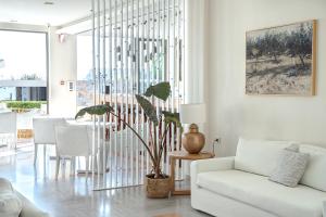 sala de estar con sofá blanco y planta en Maritimo Beach Hotel en Sissi