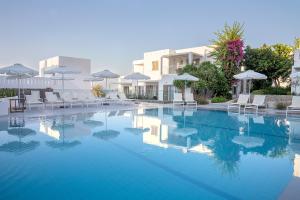 una gran piscina con sillas y sombrillas en Maritimo Beach Hotel, en Sissi