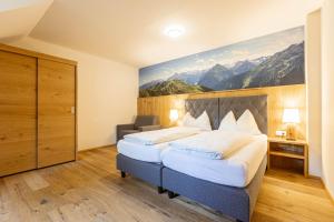 a hotel room with a bed with a painting on the wall at Vitalhof am Kreischberg by ALPS RESORTS in Bodendorf