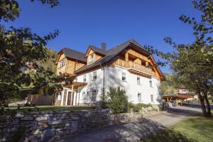 a large white house with a wooden roof at Vitalhof am Kreischberg by ALPS RESORTS in Bodendorf