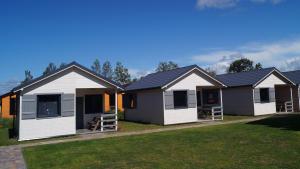 a row of modular homes on a lawn at Apartamenty Domki Pokoje WeMa Wicie in Wicie