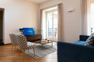 a living room with a couch and chairs and a table at The Seven Residence in Genova