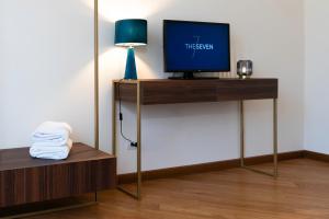 una camera con TV su un supporto con lampada di The Seven Residence a Genova
