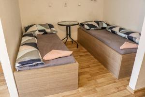 2 camas en una habitación pequeña con mesa en Penzion Kotvas, en Milovice