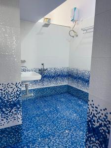 baño con lavabo y suelo de baldosa azul en Twin Room, en Nagpur