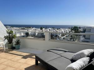 a balcony with a couch and a view of the ocean at Ocean Kiss Apartment in Puerto del Carmen