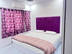 1 dormitorio con cama y cortina púrpura en Twin Room, en Nagpur