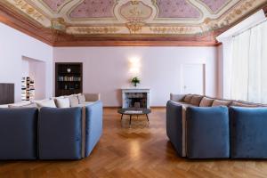 a living room with blue chairs and a fireplace at The Seven Residence in Genova