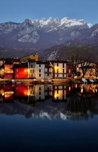 a large body of water with buildings and mountains at Casa vacanze nonna Prassede Alloggio incantevole in casa indipendente .. in Lecco